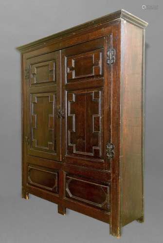 A CHARLES II STYLE OAK PANELLED CUPBOARD, with a swept mould...