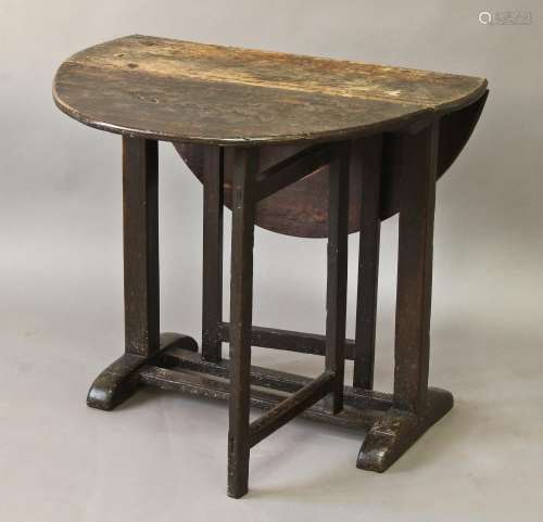 A 17TH/18TH CENTURY OAK DROP FLAP TABLE, the oval top on cen...