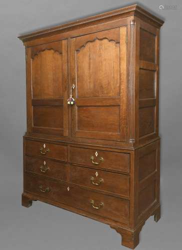 A GEORGE III OAK LIVERY CUPBOARD, the upper section with a m...