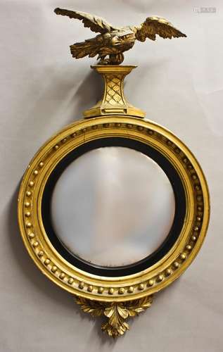 A REGENCY CONVEX GILT WOOD WALL MIRROR, the circular convex ...