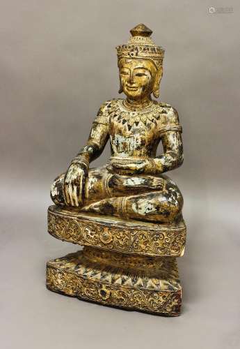 A DECORATIVE CARVED AND GILT THAI BUDDHA, the figure wearing...