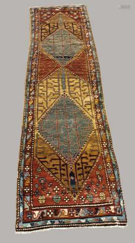 NORTH WEST PERSIAN RUNNER, circa 1920. The chestnut brown fi...