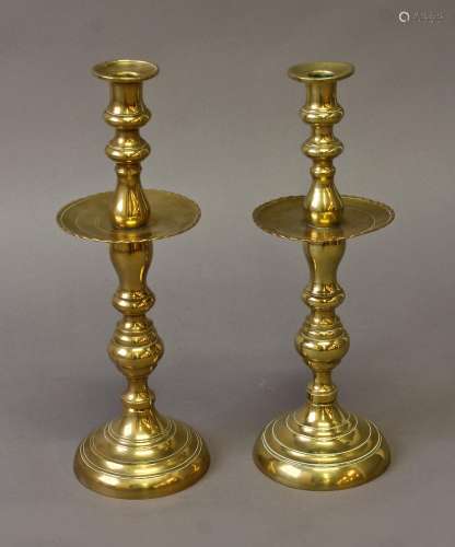 A PAIR OF MOROCCAN BRASS CANDLESTICKS, with broad sconces an...