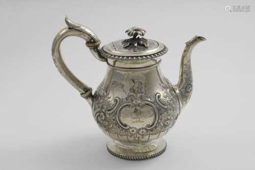 A GEORGE III EMBOSSED TEA POT with a baluster body, a c-scro...