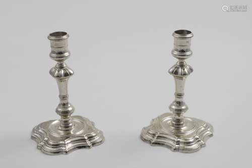 A PAIR OF GEORGE II CAST CANDLESTICKS on shaped square bases...