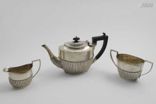 AN EDWARDIAN THREE-PIECE TEA SET with part-fluted oval bodie...