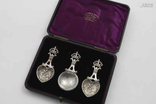 AN UNUSUAL CASED SET OF THREE CADDY SPOONS each with an open...