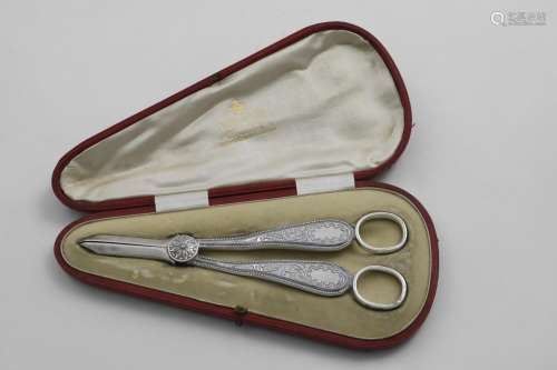 AN EDWARDIAN CASED PAIR OF GRAPE SHEARS with chased decorati...
