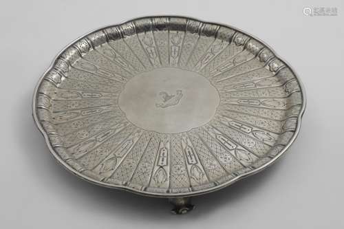 A VICTORIAN SALVER of shaped circular outline on scroll feet...