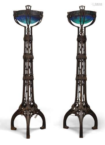 A pair of modern iron and glass uplighter floor lamps in the...