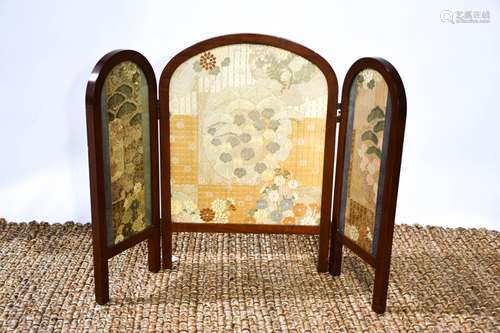 An Edwardian mahogany folding fire screen with fine needlewo...