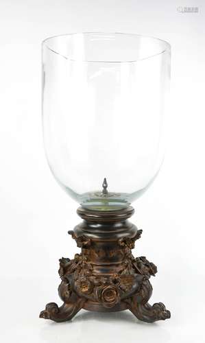 A large glass candle holder, with a faux-wood base depicting...