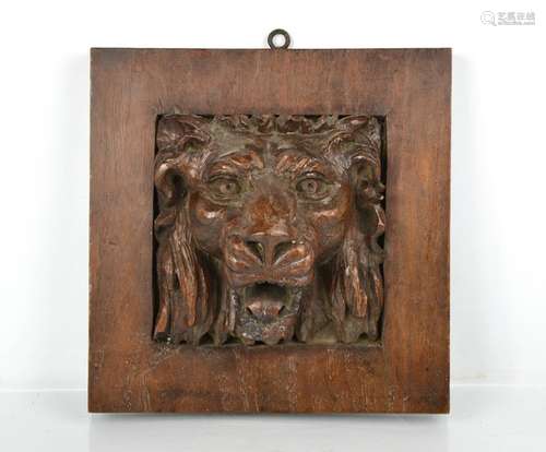 A 19th century carved oak panel depicting a protruding lion ...