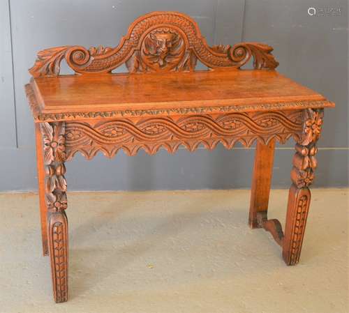 A heavily carved green man mahogany side table, 96h by 107cm...