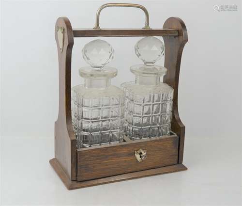 An oak tantalus with two decanters