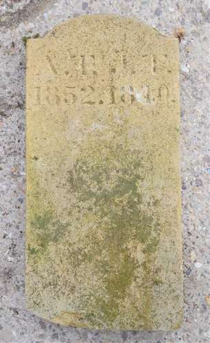 A stone gravestone, bearing hand carved inscription.