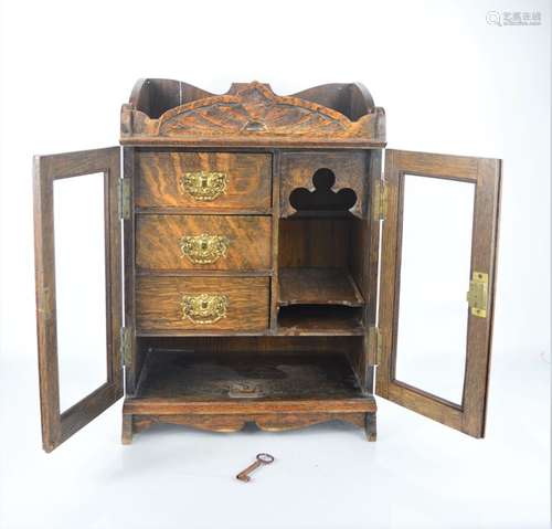 An oak smokers cabinet with three interior drawers with orig...