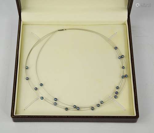 An 18ct white gold and grey pearl necklace, with three stran...