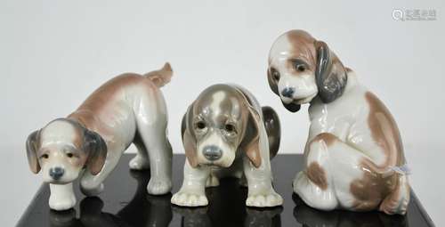 Three Lladro porcelain figurines; each puppy in differing po...