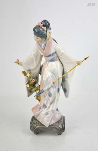 A Lladro porcelain geisha girl holding an umbrella and picki...