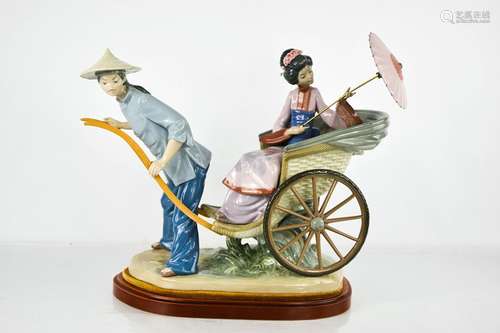 A large Lladro porcelain figure group titled The Rickshaw Ri...