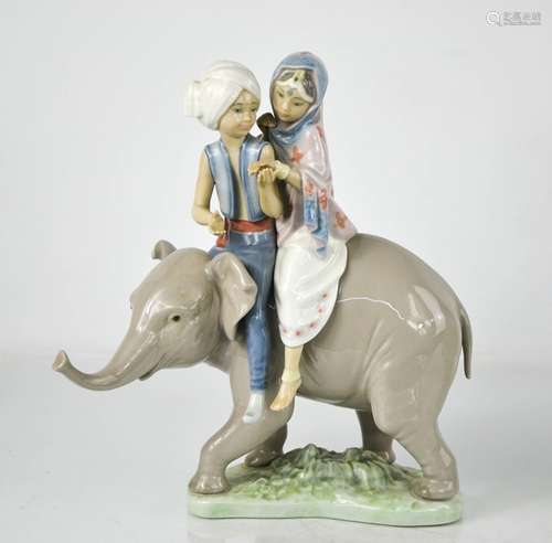 A Lladro porcelain figure group; two Hindu children riding a...