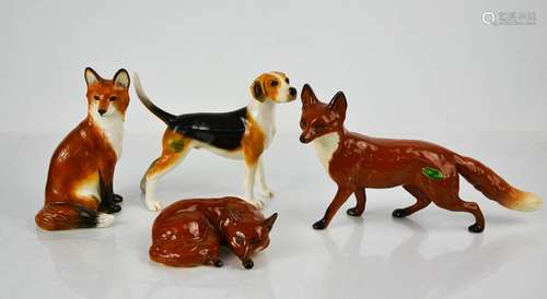 Three Beswick porcelain foxes in various poses, and a hound ...