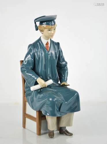 A Lladro porcelain figurine, Boy Graduate, signed to the bas...