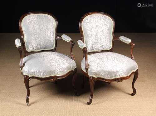 A Pair of Victorian Upholstered Armchairs with sweeping rose...