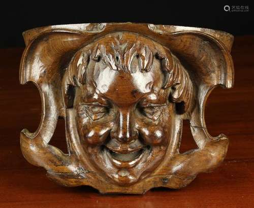 A Relief Carved Wooden Wall Bracket emblazoned with the face...