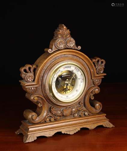 A Standing Aneroid Barometer in a carved oak case on bracket...