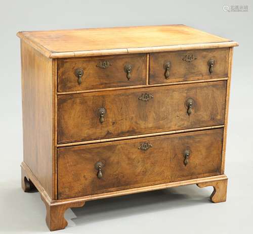 A SMALL FEATHER BANDED AND CROSSBANDED WALNUT CHEST OF DRAWE...