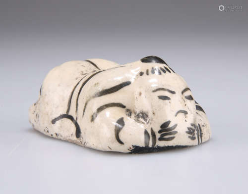 A JIZHOU KILN BRUSH REST IN THE FORM OF A CHILD, LATE YUAN D...