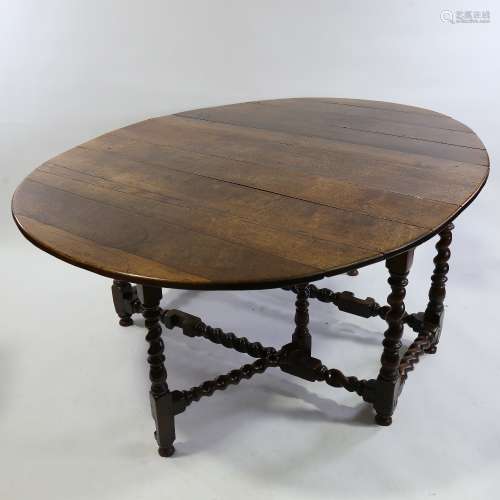 A large 18th century solid oak oval gateleg dining table, wi...