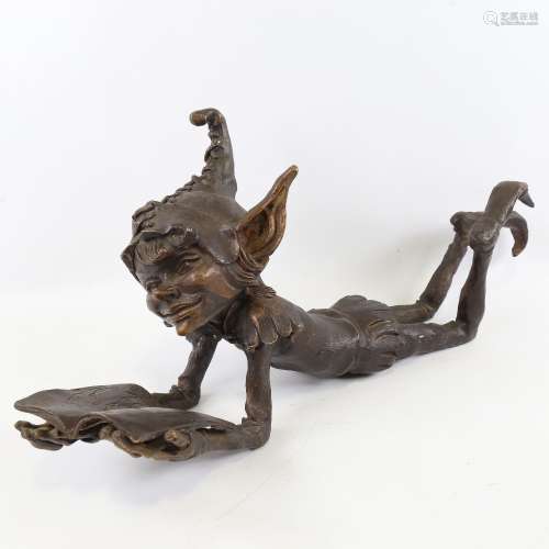 A patinated bronze sculpture of a goblin reading a book, len...