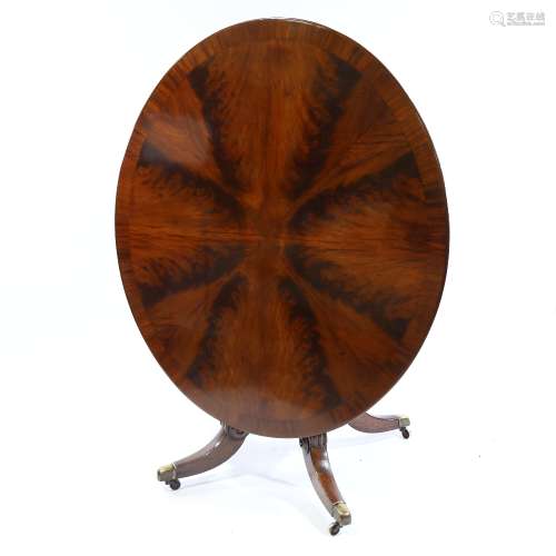 A 19th century oval mahogany tilt-top dining table, with seg...