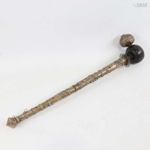 An Oriental unmarked white metal ceremonial pipe with wooden...