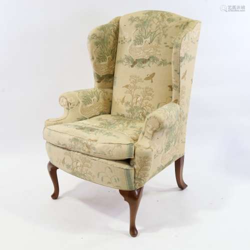 A Georgian style upholstered wing armchair, with Oriental de...