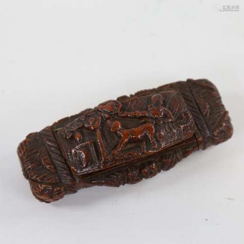 A 19th century stained coquilla nut snuffbox, the lid carved...