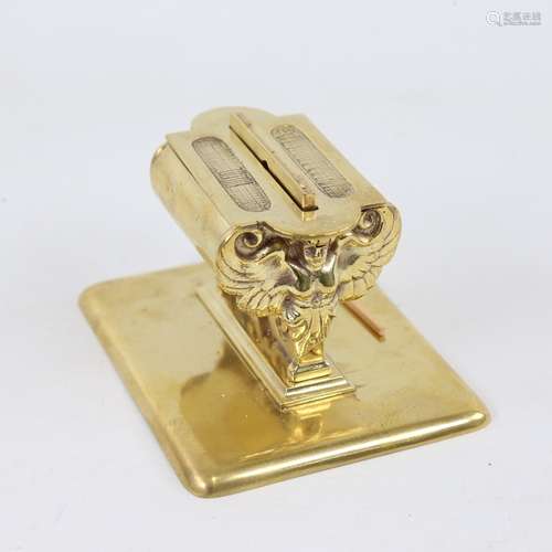 An early 20th century brass desktop match dispenser, support...