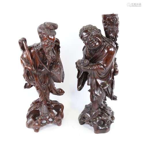 A pair of Chinese carved and stained hardwood standing figur...