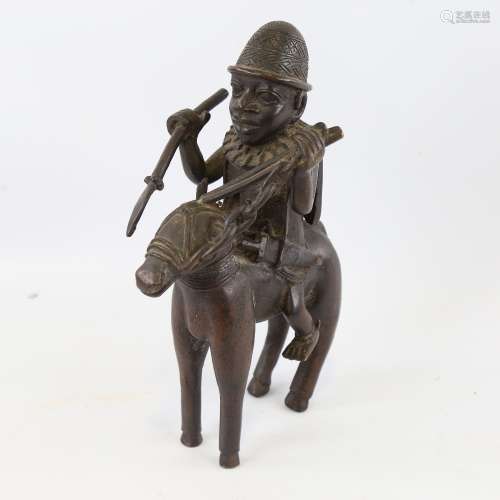 A rare 17th century Benin bronze warrior king astride a hors...