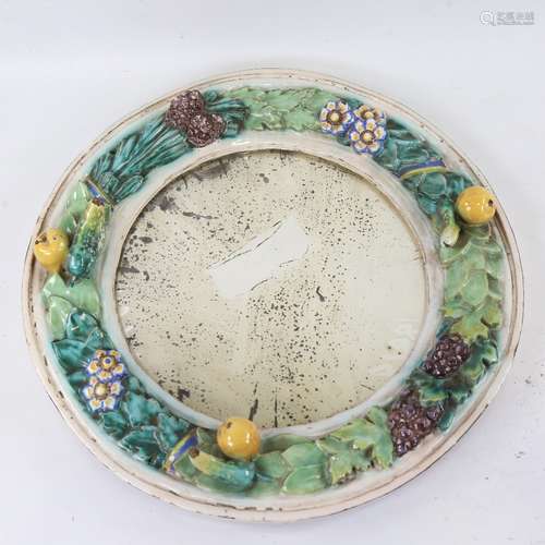 A Continental faience pottery circular wall mirror, relief m...