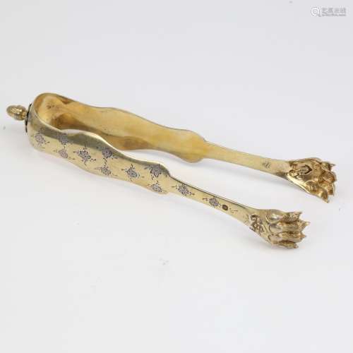 A pair of 19th century French silver-gilt lion paw sugar ton...