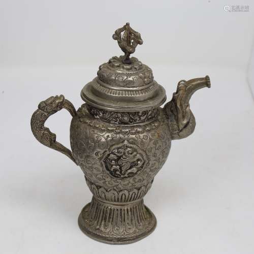 An Indian unmarked white metal teapot, relief embossed decor...
