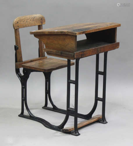 A late Victorian oak and cast iron school desk, height 85cm,...