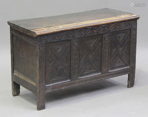 An 18th century oak panelled coffer with later carved decora...