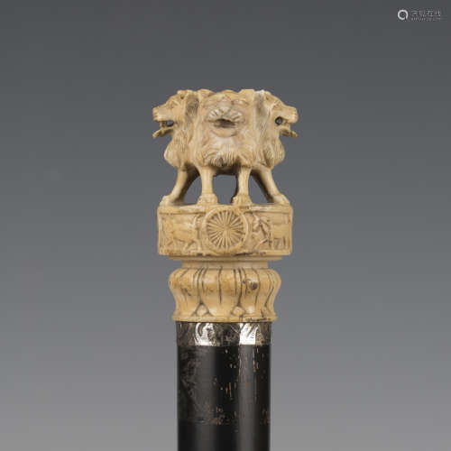 A 19th century ebonized walking cane, the ivory handle finel...