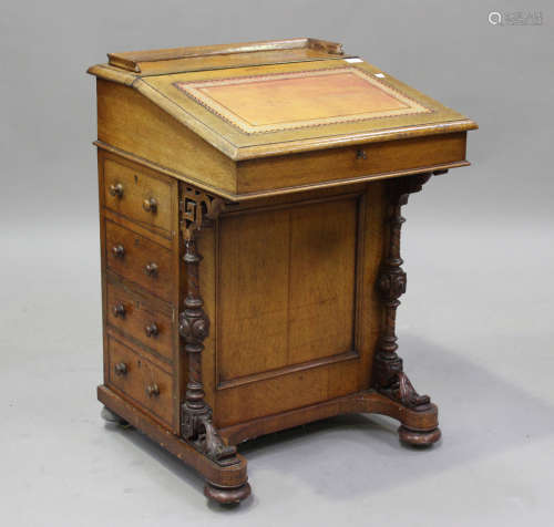 A Victorian oak Davenport desk, the hinged writing surface a...