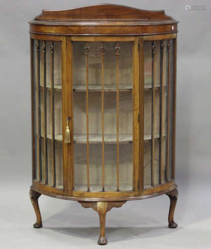 An early 20th century walnut bowfront display cabinet, raise...